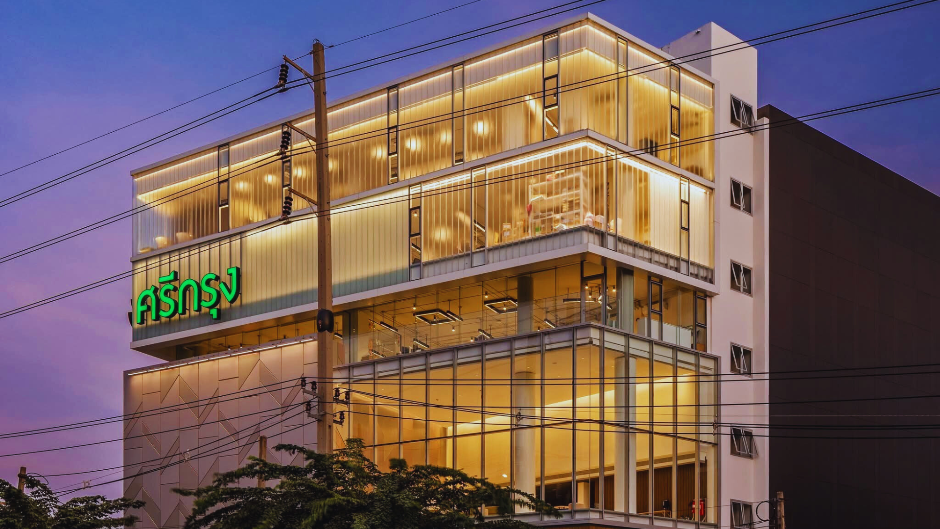 ONE-M supervised project — a contemporary glass headquarters illuminated at dusk